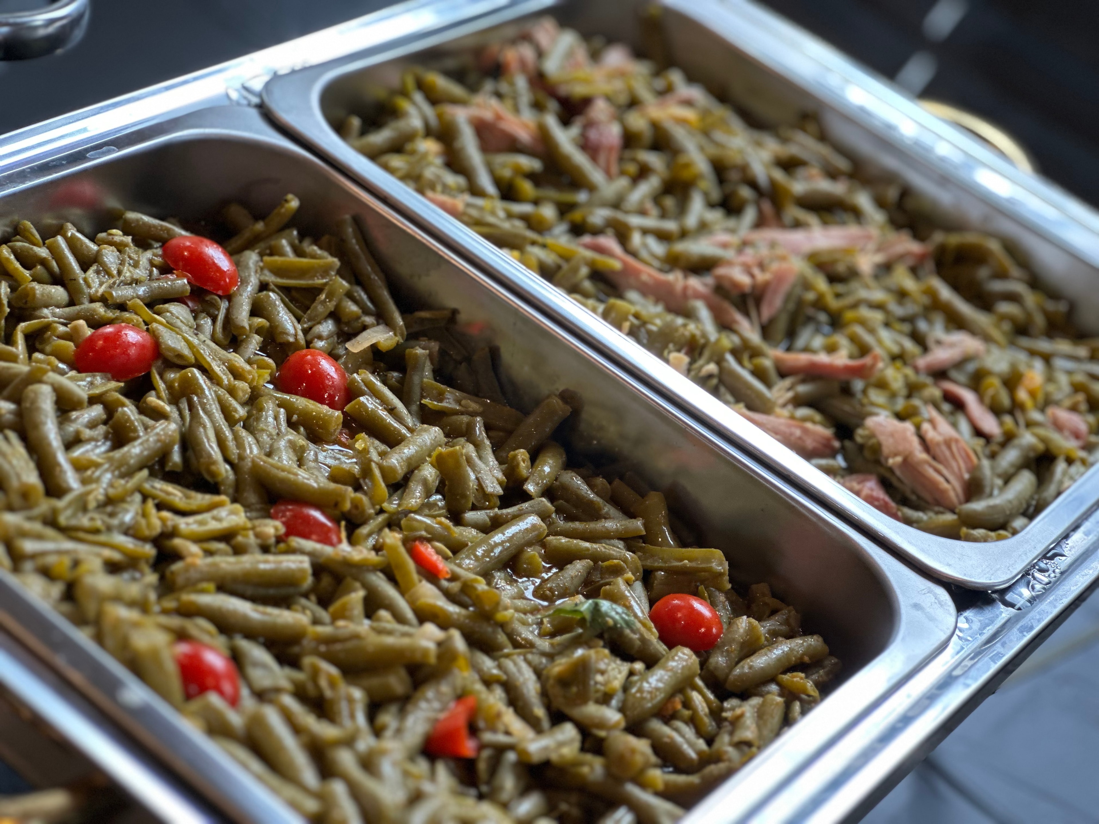 Southern-style green beans with cherry tomatoes in chafing dishes