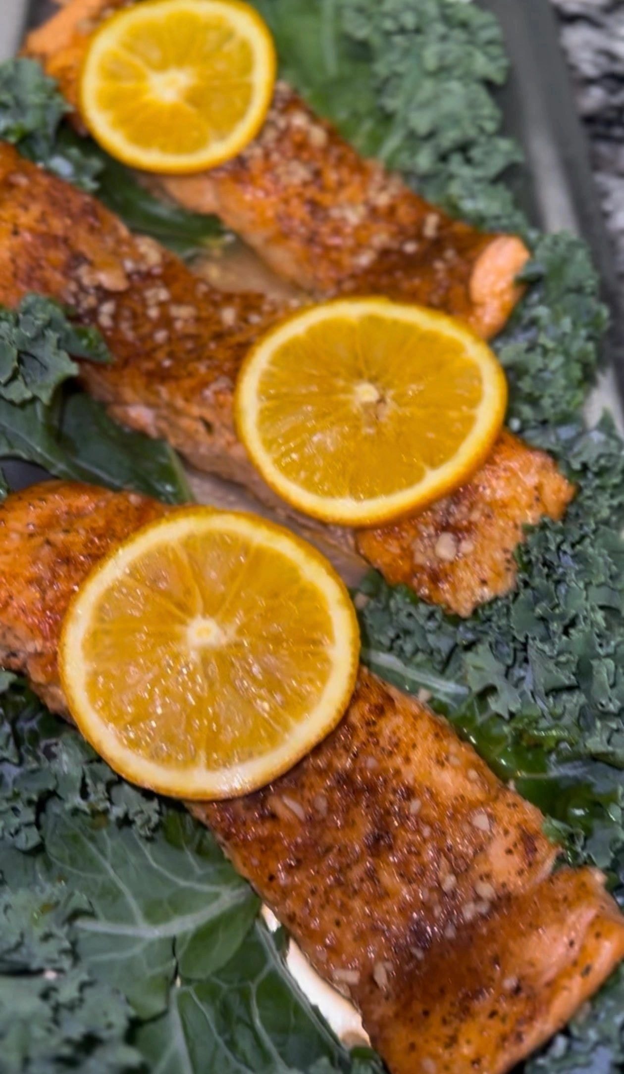 Seared salmon fillet with orange and kale garnish